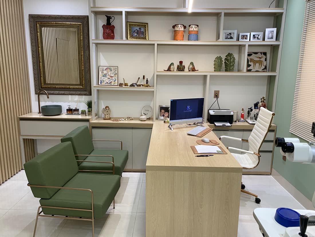 Consultório do Dr. Luigi, com mesa de atendimento e poltronas verdes para os pacientes